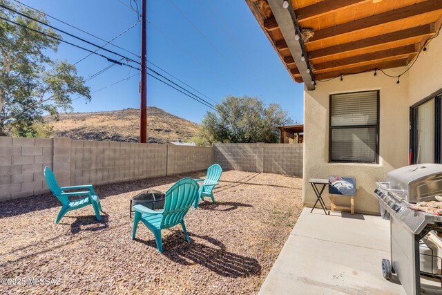 1320 S Via Estrella Roja, Tucson, AZ 85713 - fenced backyard with a fire pit, a mountain view, and a patio