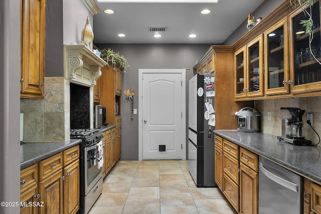 1351 Alma Ct, Rio Rico, AZ 85648 - kitchen with brown cabinets, appliances with stainless steel finishes, and tasteful backsplash