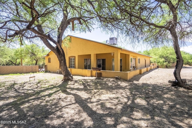 1351 Alma Ct, Rio Rico, AZ 85648 - rear view of property featuring cooling unit, stucco siding, and fence