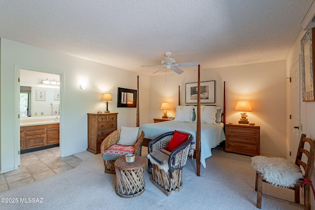 bedroom with connected bathroom, a textured ceiling, ceiling fan, and light carpet