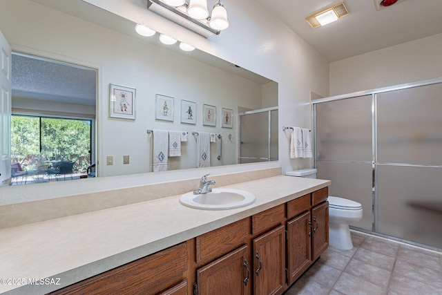 bathroom with vanity, tile patterned flooring, a shower with door, and toilet