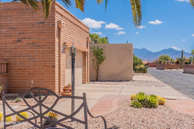 view of patio / terrace with a mountain view, an attached garage, and driveway