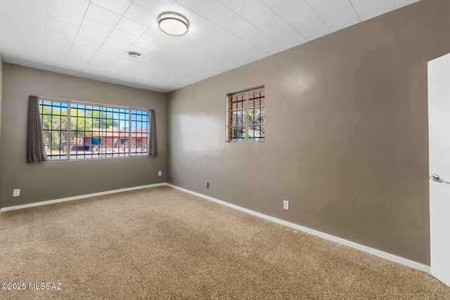 spare room with concrete flooring, visible vents, and baseboards