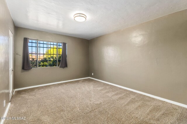 carpeted spare room featuring wooden walls and visible vents