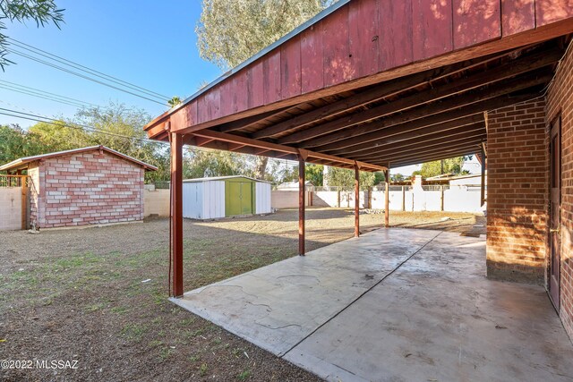 view of patio / terrace featuring a fenced backyard, an outbuilding, and a shed