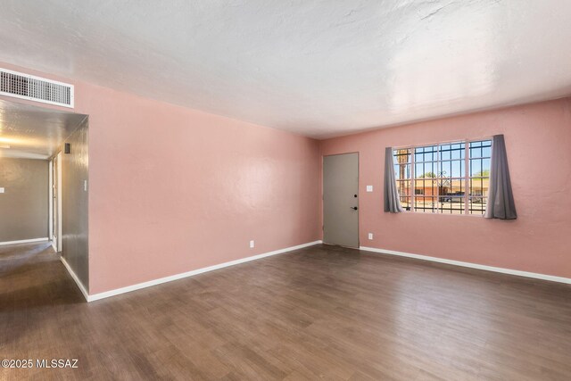 unfurnished living room featuring baseboards and finished concrete flooring