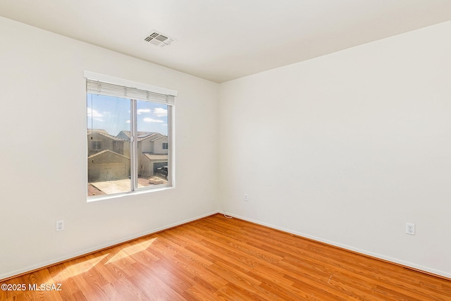 unfurnished room with baseboards, visible vents, and light wood finished floors