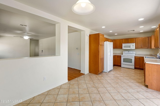 kitchen with recessed lighting, light countertops, visible vents, a sink, and white appliances