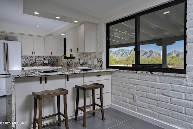 1720 W Cessna Way, Tucson, AZ 85755 - kitchen featuring light stone countertops, white cabinetry, tasteful backsplash, high end white refrigerator, and recessed lighting