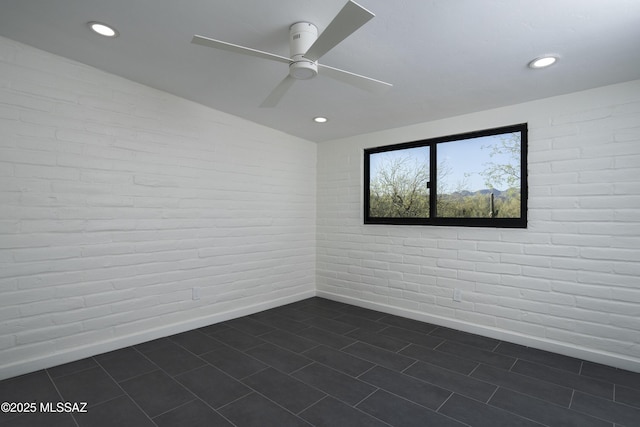 1720 W Cessna Way, Tucson, AZ 85755 - unfurnished room featuring a ceiling fan, recessed lighting, baseboards, brick wall, and dark tile patterned floors