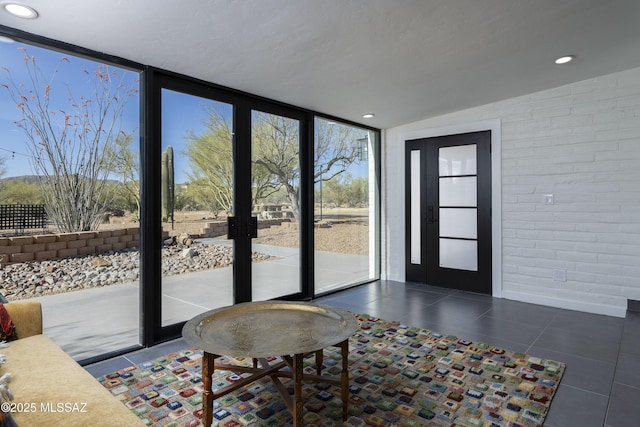 1720 W Cessna Way, Tucson, AZ 85755 - doorway with floor to ceiling windows, vaulted ceiling, tile patterned flooring, recessed lighting, and brick wall