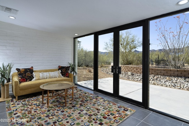 1720 W Cessna Way, Tucson, AZ 85755 - tiled living area featuring expansive windows, a mountain view, recessed lighting, and brick wall