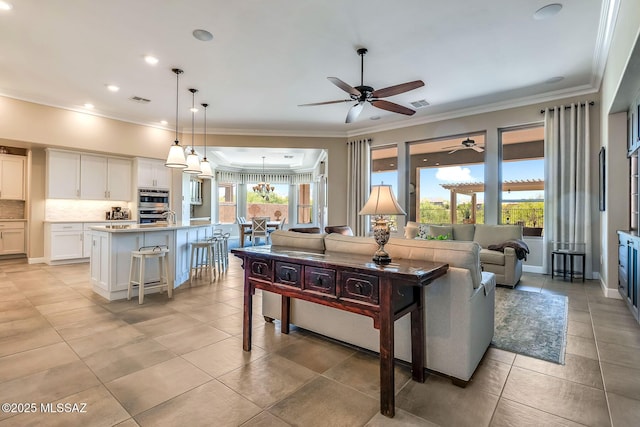 living area featuring ceiling fan, crown molding, light tile patterned floors, and visible vents