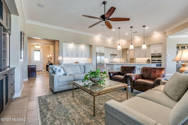 living area with light tile patterned floors, baseboards, a ceiling fan, and ornamental molding