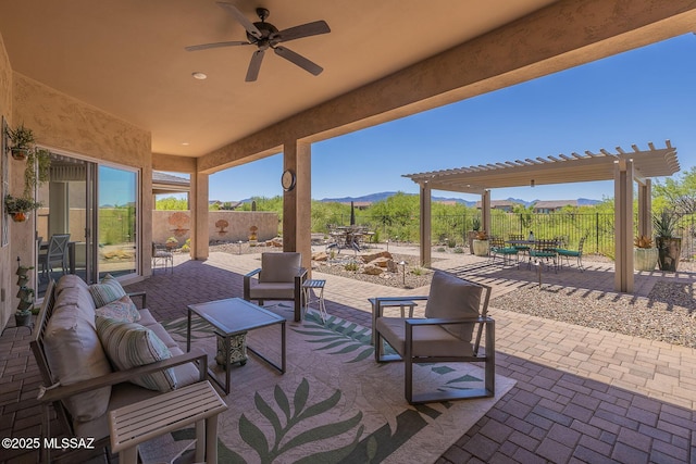 view of patio featuring a mountain view, an outdoor living space, a fenced backyard, a pergola, and a ceiling fan