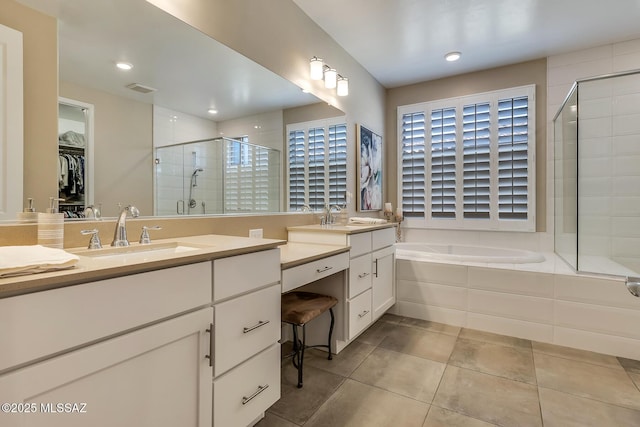bathroom with a stall shower, visible vents, tile patterned flooring, vanity, and a spacious closet