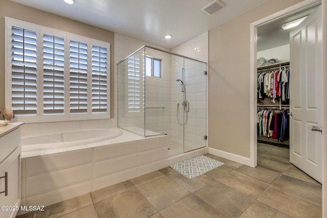 full bath with a garden tub, visible vents, a stall shower, and a spacious closet