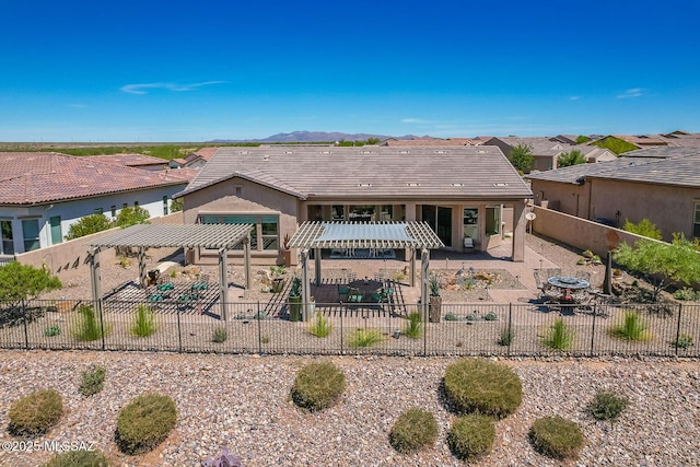 back of property with a playground, a tiled roof, a pergola, a fenced backyard, and a patio area