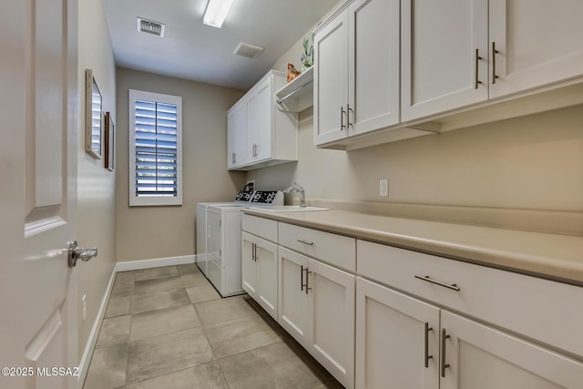 laundry area featuring a sink, cabinet space, visible vents, baseboards, and independent washer and dryer
