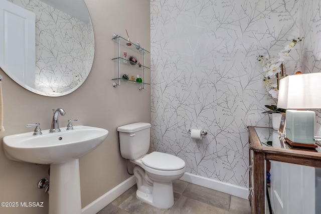 bathroom with toilet and baseboards