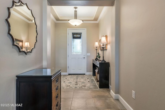 entryway with baseboards, a tray ceiling, and crown molding