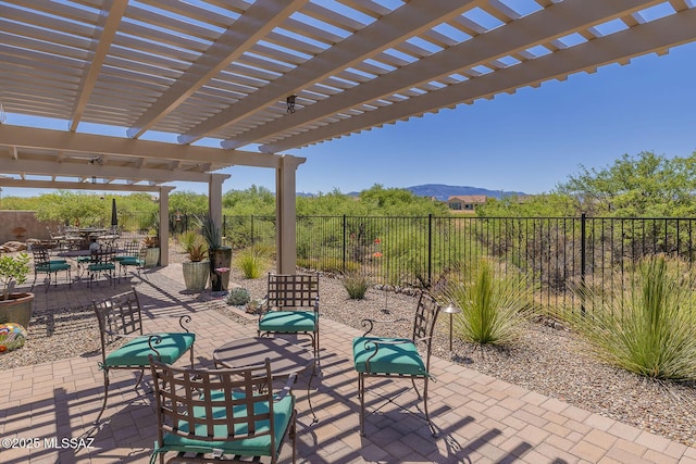 view of patio / terrace with a pergola, a mountain view, and fence