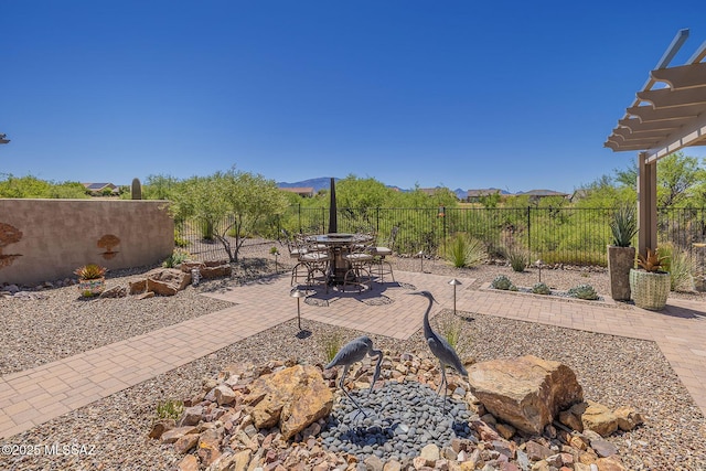 view of patio / terrace featuring a mountain view, a fenced backyard, and outdoor dining space
