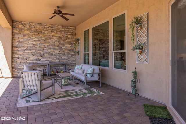 view of patio with an outdoor living space and ceiling fan