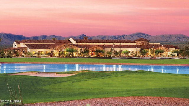 surrounding community featuring a water and mountain view, golf course view, and a lawn