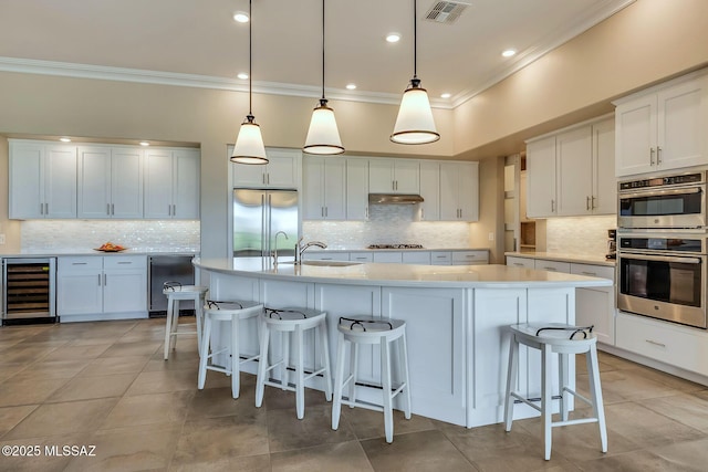 kitchen with beverage cooler, a sink, crown molding, backsplash, and appliances with stainless steel finishes