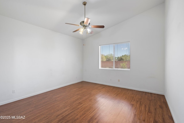 unfurnished room featuring baseboards, a ceiling fan, wood finished floors, and vaulted ceiling