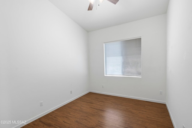 unfurnished room featuring baseboards, ceiling fan, and dark wood-type flooring