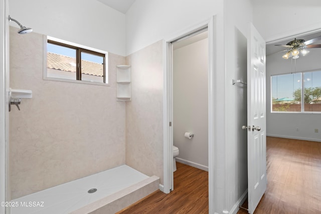 bathroom with a stall shower, a ceiling fan, wood finished floors, and toilet