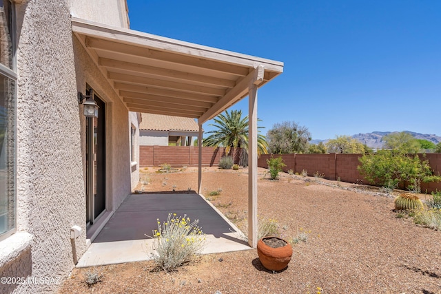 view of yard with a fenced backyard, a patio, and a mountain view