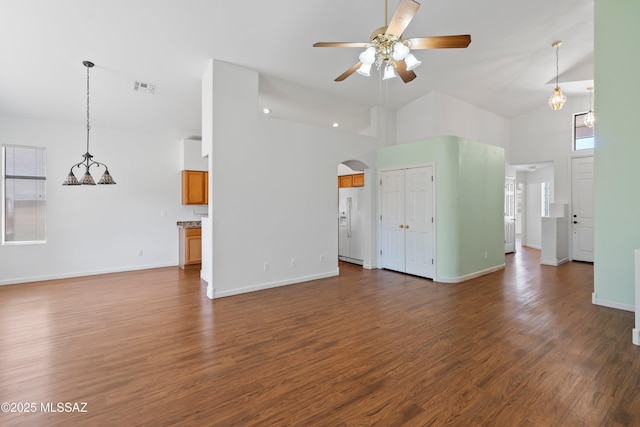 unfurnished living room featuring arched walkways, high vaulted ceiling, a ceiling fan, dark wood-type flooring, and visible vents