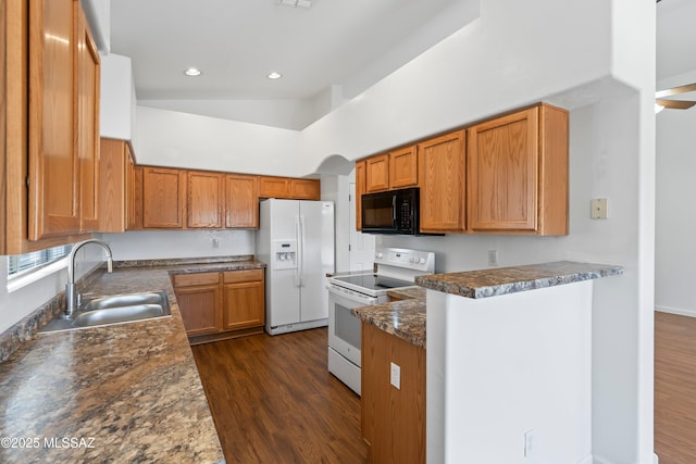 kitchen with a sink, brown cabinets, dark wood-style floors, and white appliances