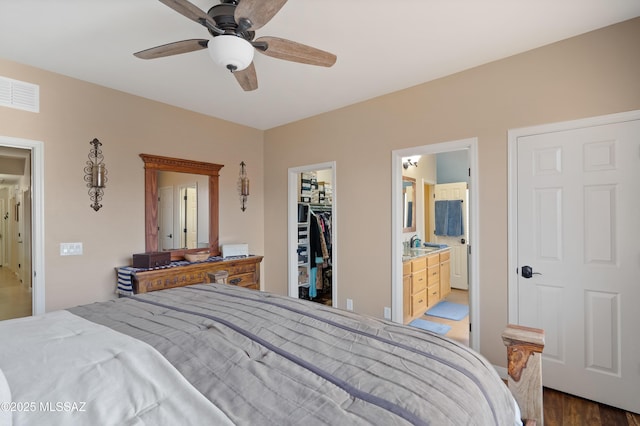 12489 N Owl Head Canyon Rd, Marana, AZ 85658 - bedroom featuring visible vents, ensuite bathroom, wood finished floors, a spacious closet, and a closet