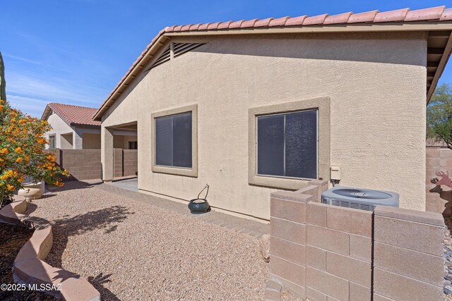 12489 N Owl Head Canyon Rd, Marana, AZ 85658 - rear view of property featuring fence, stucco siding, central AC unit, a patio area, and a tiled roof