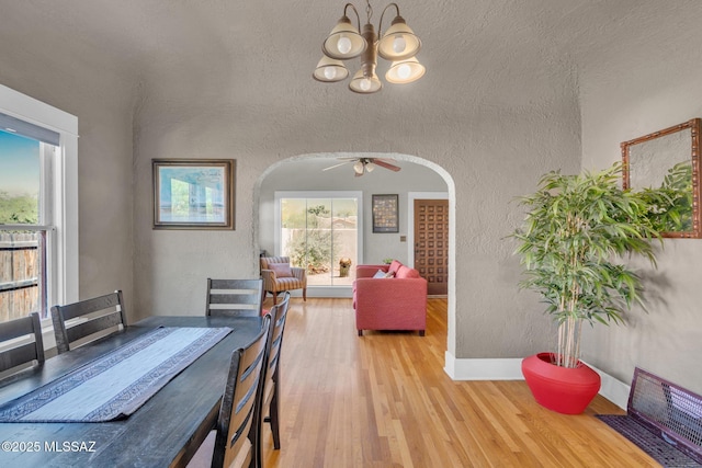 2716 E 6th St, Tucson, AZ 85716 - dining area with arched walkways, a textured wall, light wood-type flooring, a chandelier, and a ceiling fan