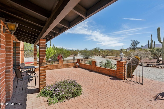 view of patio featuring a mountain view and fence