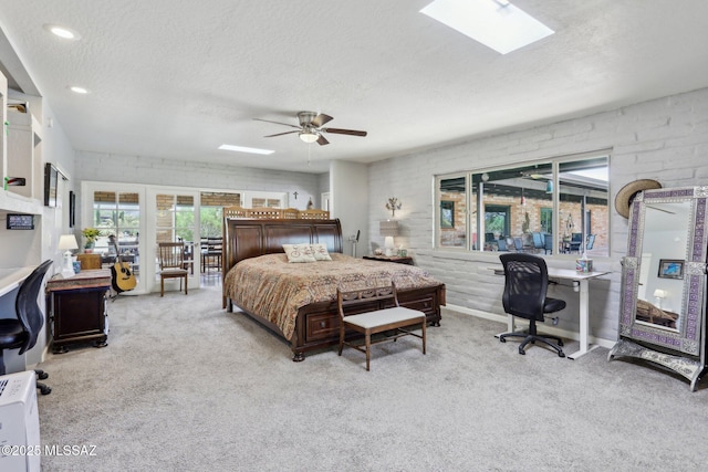 bedroom with light colored carpet, a textured ceiling, and a skylight