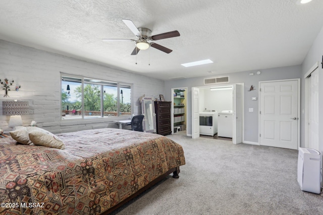 carpeted bedroom featuring separate washer and dryer, a textured ceiling, ceiling fan, and visible vents