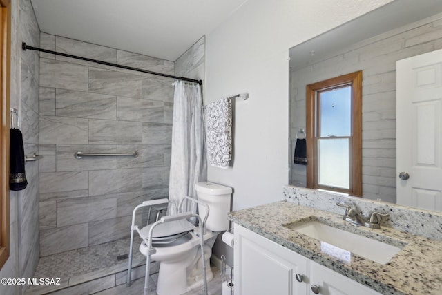 bathroom featuring vanity, a tile shower, and toilet