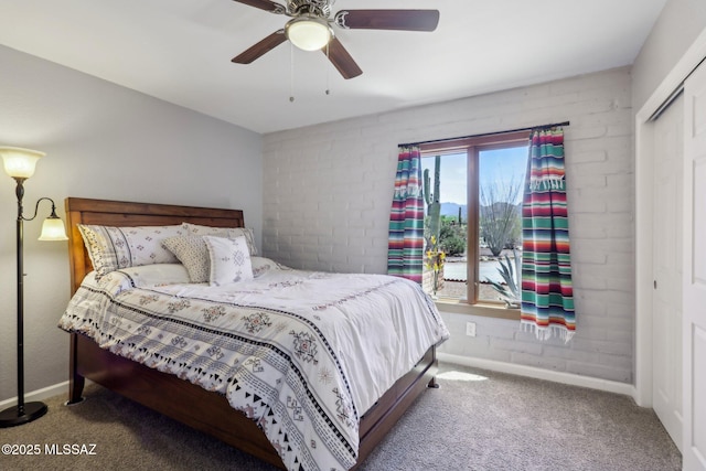 bedroom with a closet, baseboards, ceiling fan, and carpet flooring