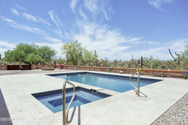 view of pool with a fenced in pool, an in ground hot tub, a patio area, and a fenced backyard