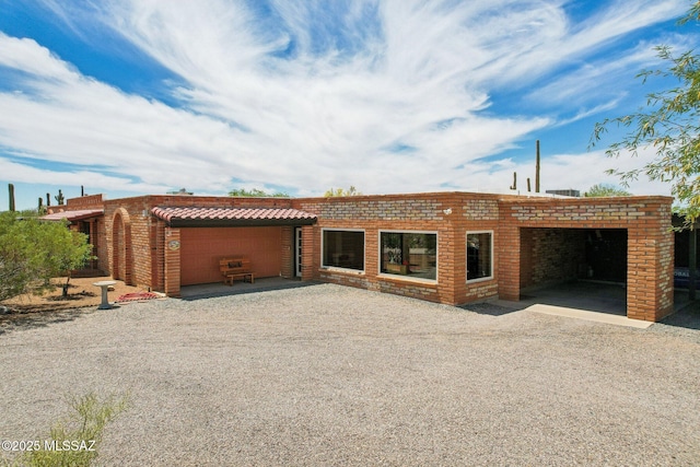 view of front of home featuring brick siding, driveway, and a garage