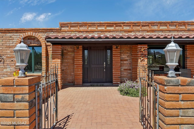 doorway to property with a gate and a tiled roof