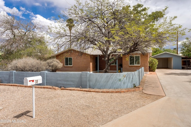 38 N Irving Ave, Tucson, AZ 85711 - view of front of property featuring a detached carport, driveway, fence private yard, and brick siding