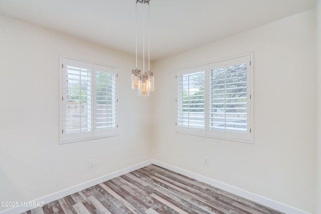 38 N Irving Ave, Tucson, AZ 85711 - empty room with plenty of natural light, wood finished floors, baseboards, and a notable chandelier