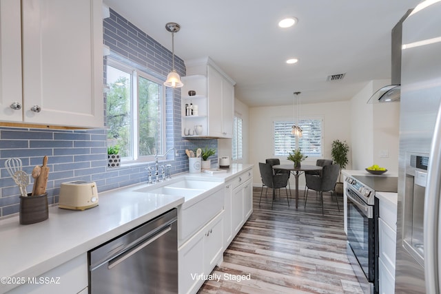 38 N Irving Ave, Tucson, AZ 85711 - kitchen featuring light wood-type flooring, appliances with stainless steel finishes, white cabinetry, and a sink